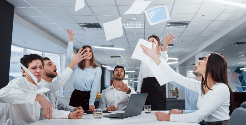 All papers up in the air. Job is done. Group of office workers happy to hit their own records and being successful.