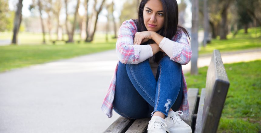 mulher introvertida sentada no banco